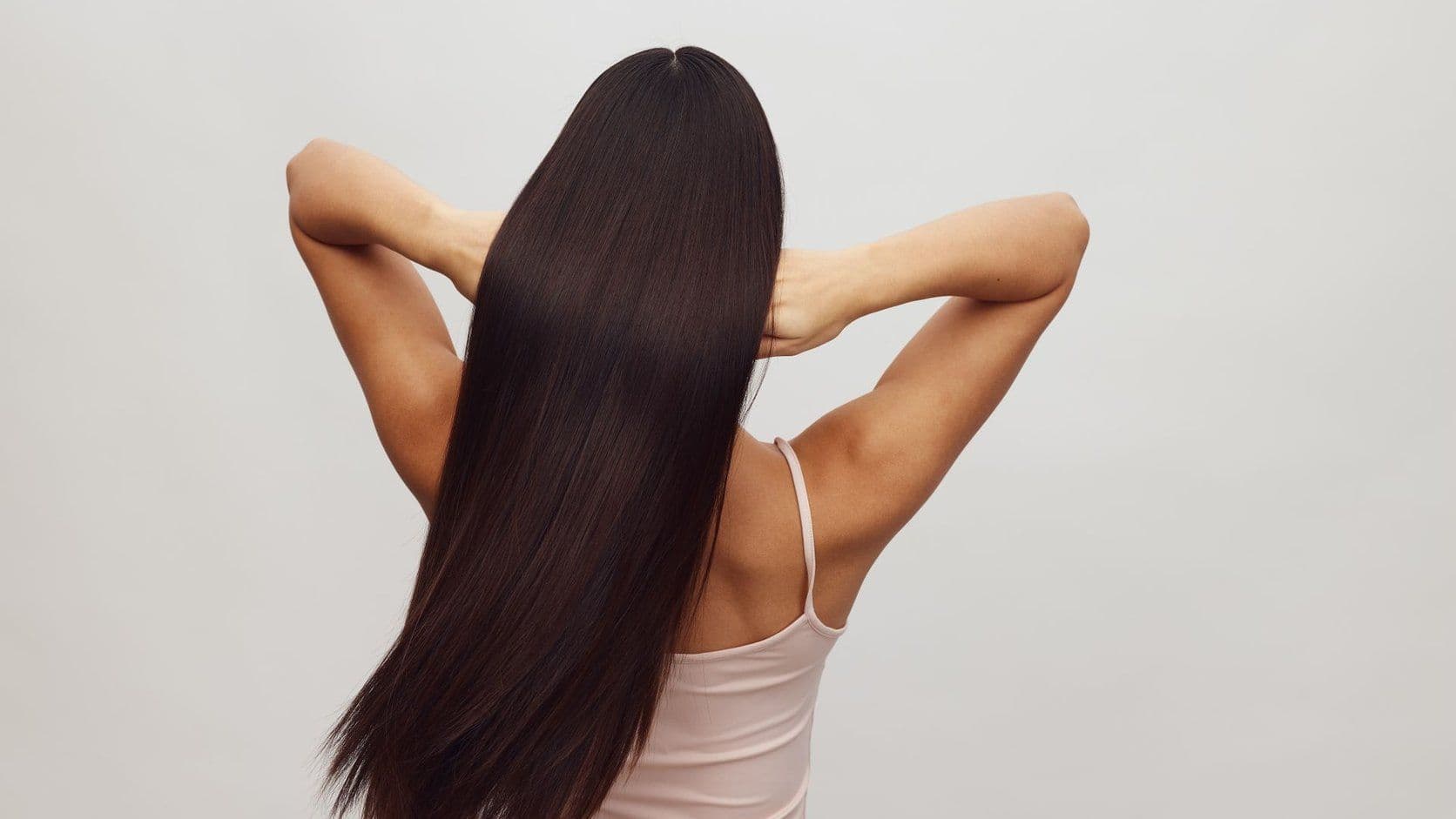 Back view of a woman with long straight hair extensions.